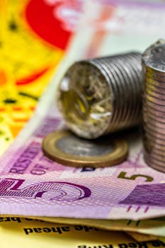 Detailed macro shot of stacked coins and currency notes showcasing financial concepts.